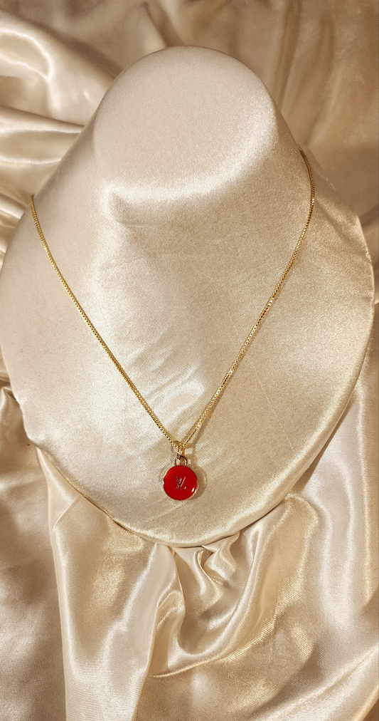 Repurposed vintage charm necklace from LV Era Collection with a red charm pendant and a solid sterling silver chain plated in gold vermeil.