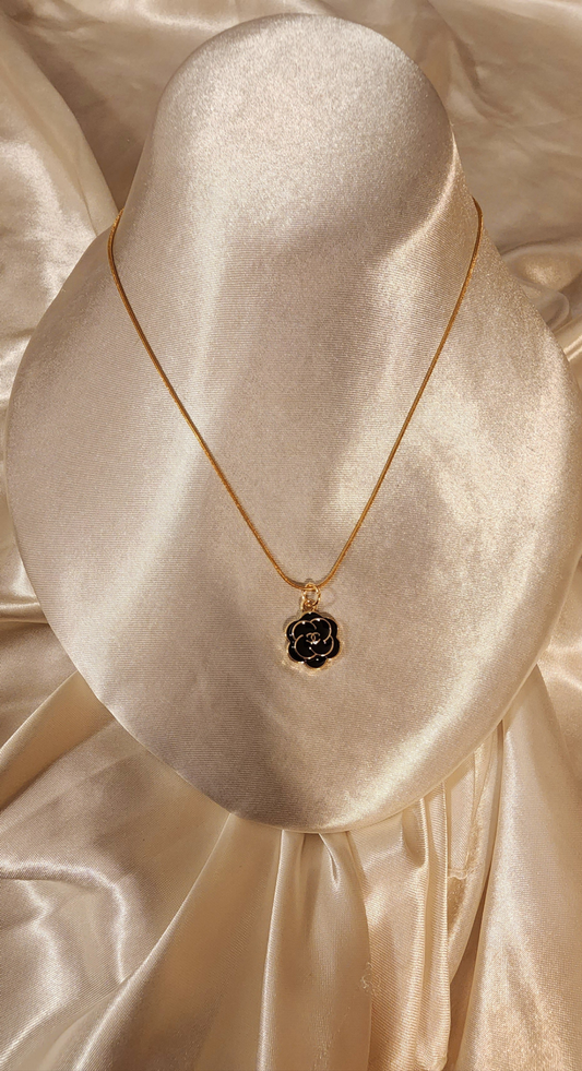 Repurposed vintage charm necklace from CC Era Collection with a black and gold camellia flower pendant and a solid sterling silver chain plated in gold vermeil.