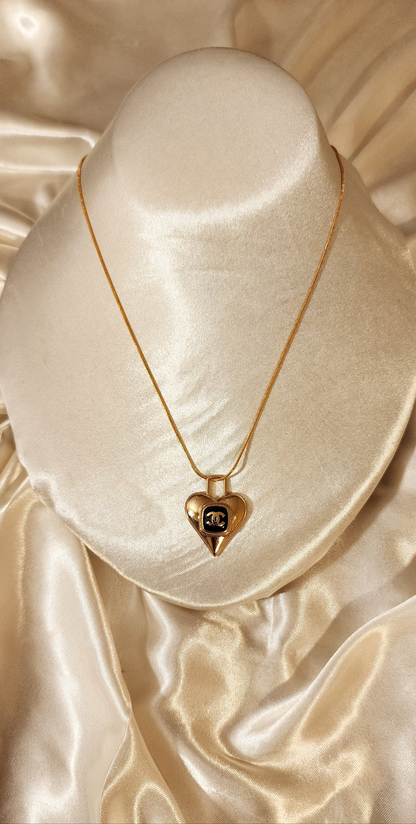 Repurposed vintage charm necklace from CC Era Collection with a delicate gold and black heart pendant and a solid sterling silver chain plated in gold vermeil.