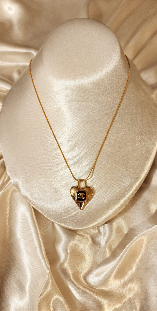 Repurposed vintage charm necklace from CC Era Collection with a delicate gold and black heart pendant and a solid sterling silver chain plated in gold vermeil.