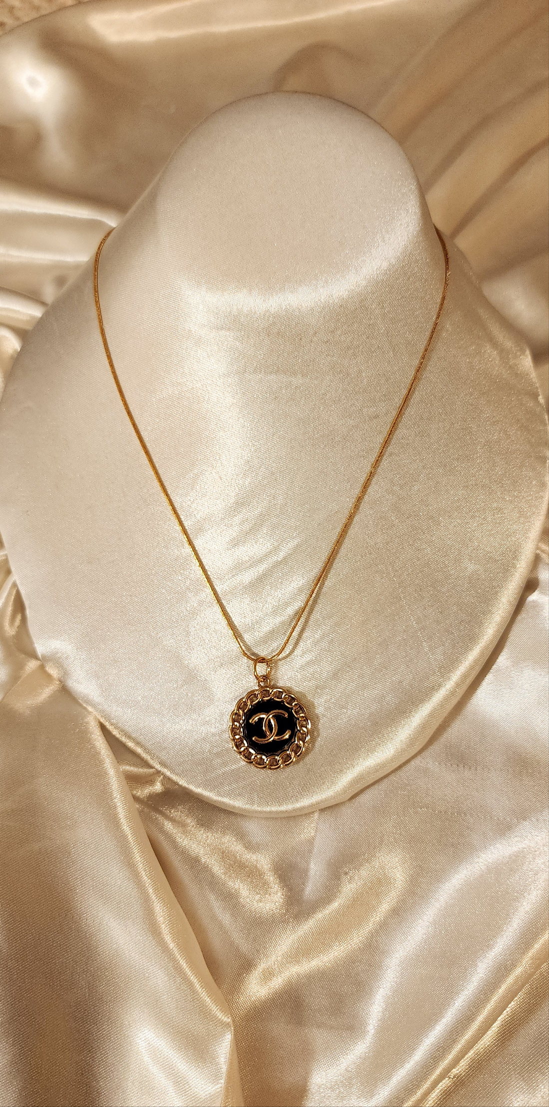 Repurposed vintage charm necklace from CC Era Collection with a gold and black button pendant and a solid sterling silver chain plated in gold vermeil.