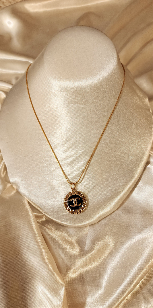 Repurposed vintage charm necklace from CC Era Collection with a gold and black button pendant and a solid sterling silver chain plated in gold vermeil.