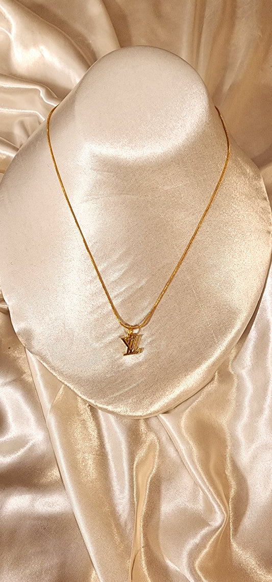 Repurposed vintage charm necklace from LV Era Collection with a mini monogram pendant and a solid sterling silver chain plated in gold vermeil.