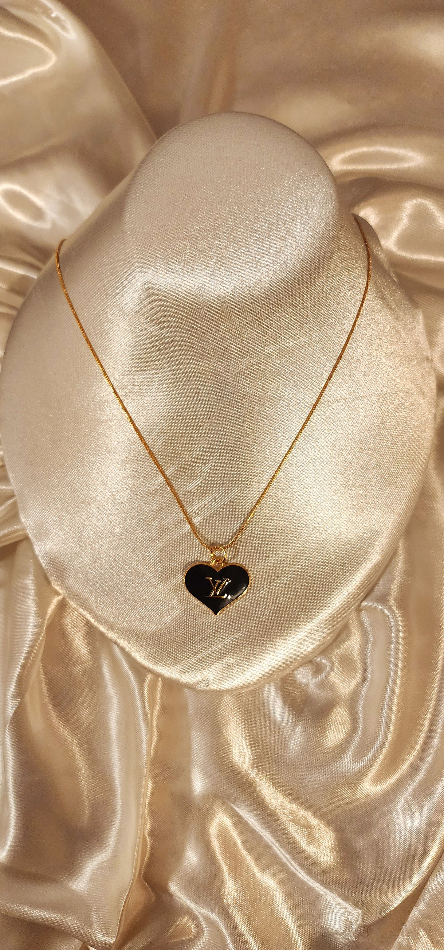 Repurposed vintage charm necklace from LV Era Collection with a black heart pendant and a solid sterling silver chain plated in gold vermeil.