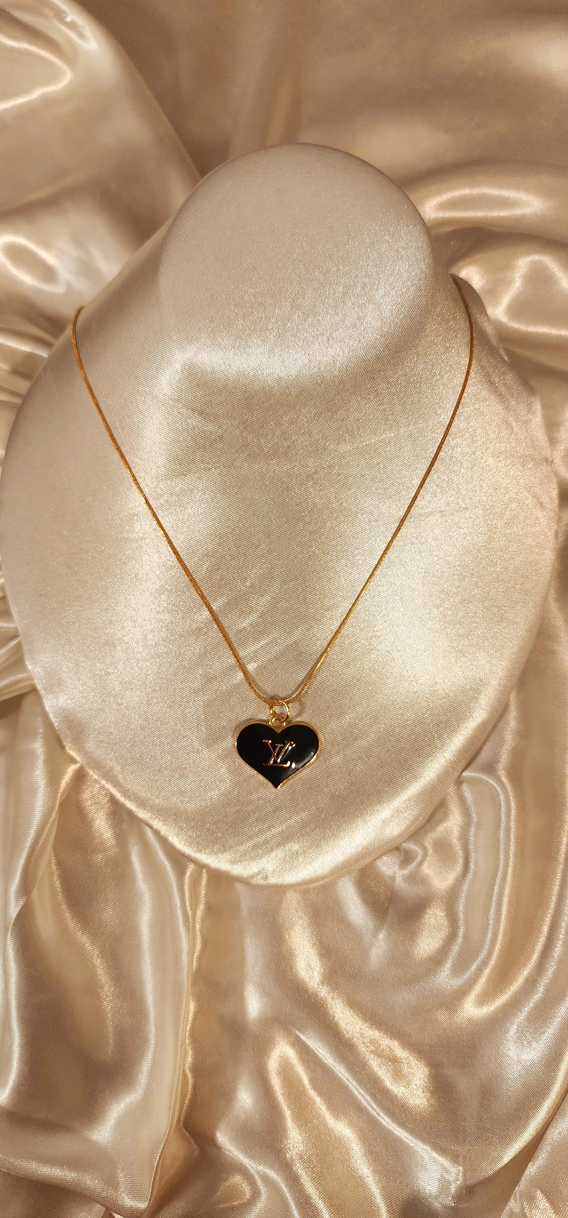 Repurposed vintage charm necklace from LV Era Collection with a black heart pendant and a solid sterling silver chain plated in gold vermeil.