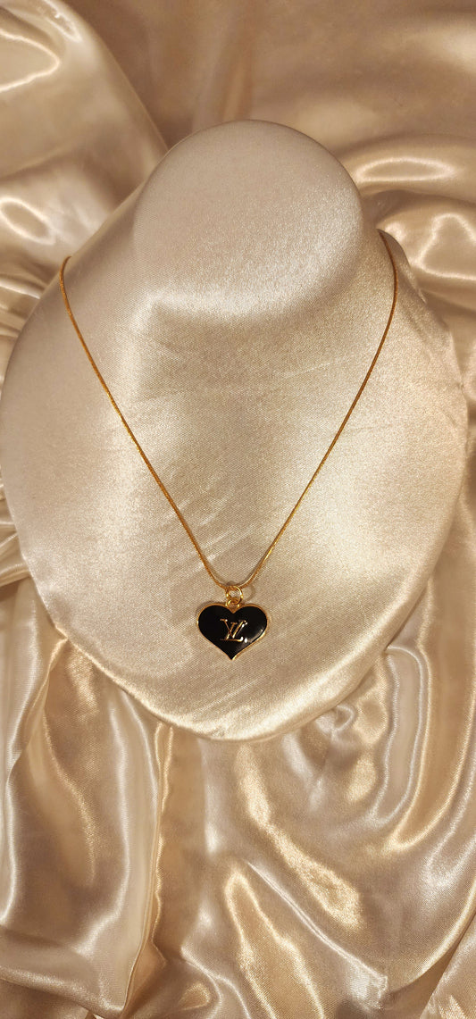 Repurposed vintage charm necklace from LV Era Collection with a black heart pendant and a solid sterling silver chain plated in gold vermeil.